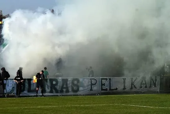 Kibice Pelikana Łowicz z banerem Ultras Pelikan w kłębach dymu podczas świętowania awansu do II ligi