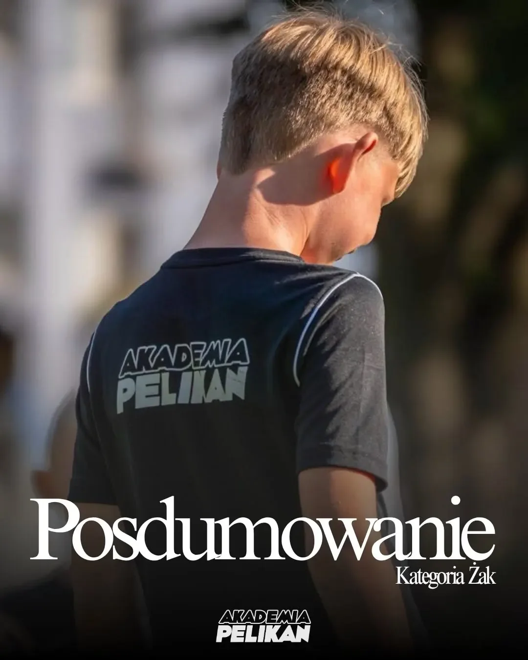 Zawodnik Akademii Pelikan w czarnej koszulce z logo klubu na plakacie podsumowującym kategorię Żak.