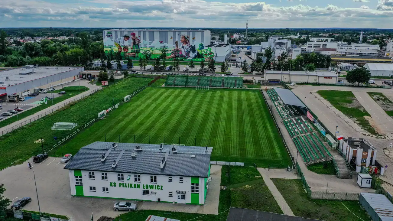Stadion Miejski w Łowiczu z lotu ptaka — murawa, trybuny i budynek klubowy KS Pelikan Łowicz.