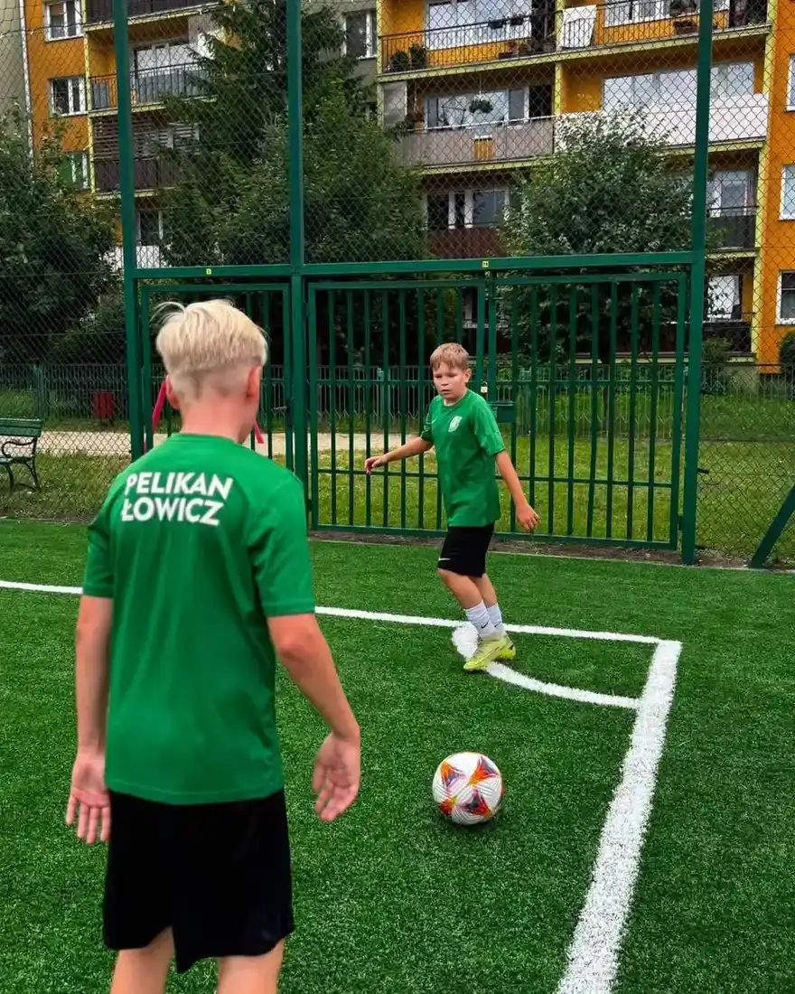 Dwaj zawodnicy w zielonych strojach rozgrywają piłkę podczas turnieju Zatorze Cup.